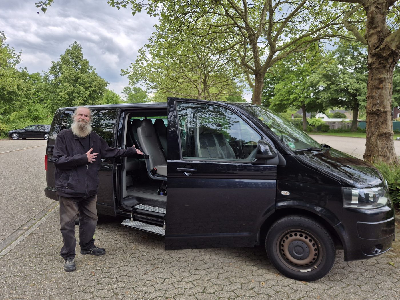 Andreas Teschner, Fahrer und Reisebegleiter von UKF-Ratingen, vor seinem schwarzen Kleinbus